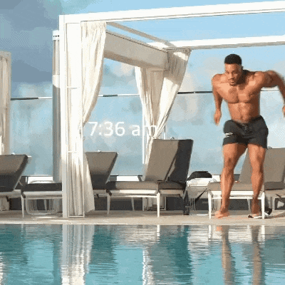 a shirtless man is jumping into a swimming pool at 6:36 am