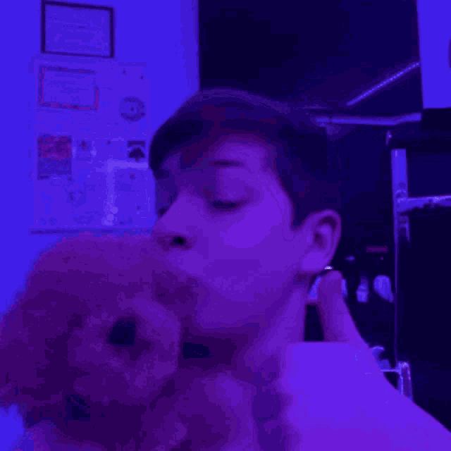 a man is taking a selfie in a room with purple lights on the ceiling .
