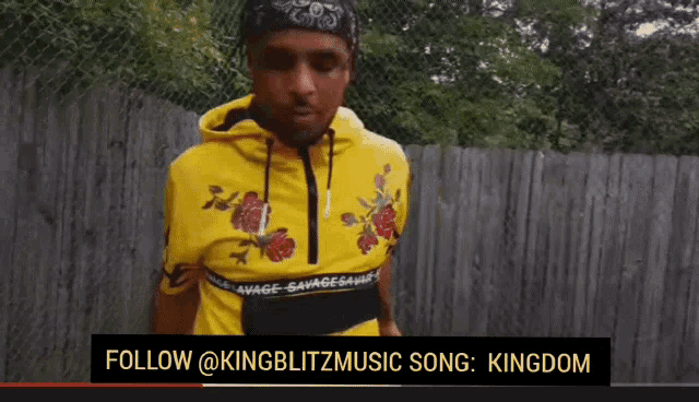 a man wearing a yellow hoodie with roses on it