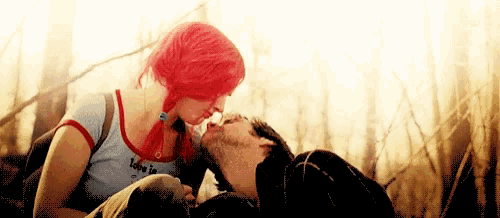 a man and a woman are kissing in a field .