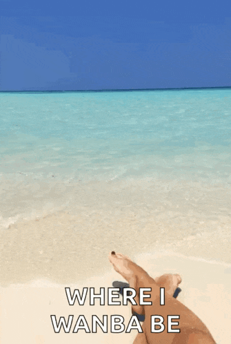 a person is laying on a beach with their feet in the water and the words where i wanba be above them
