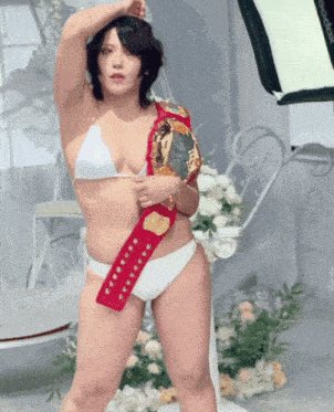 a woman in a bikini is holding a trophy