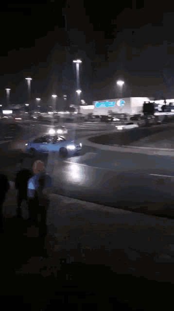 a car is driving down a highway at night in front of a walmart