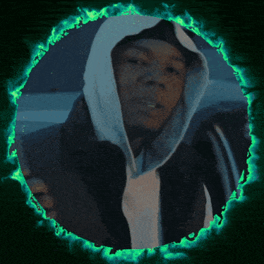 a man in a hoodie is surrounded by a green circle of fire