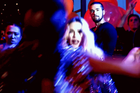 a group of people are dancing together in a dark room