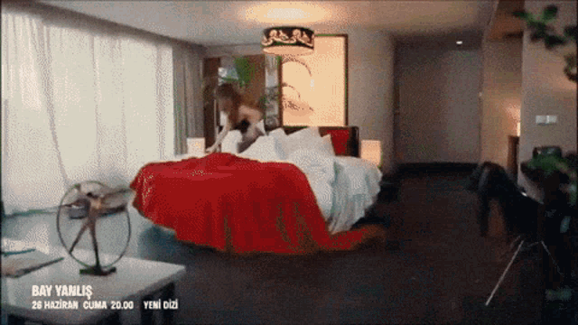 a bedroom with a red blanket and the words bay yanlis