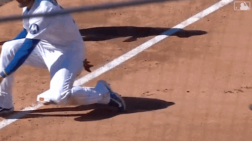 a baseball player is kneeling on the base as another player slides into base