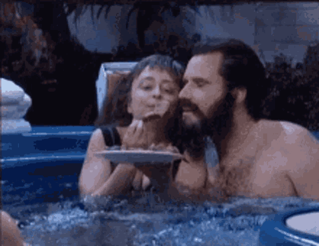 a man and a woman are sitting in a hot tub
