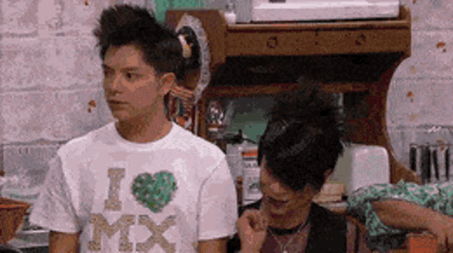 a man wearing an i love mx t-shirt stands next to a woman