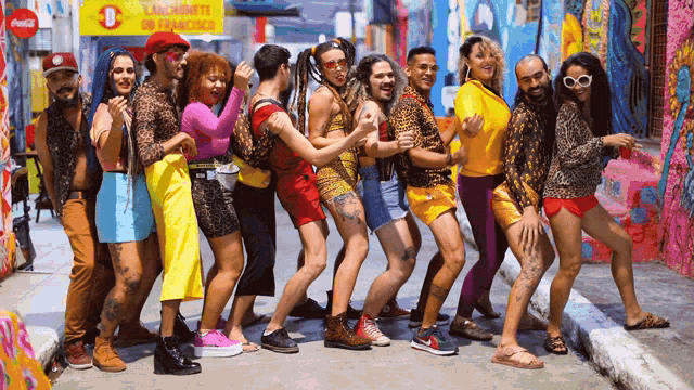 a group of people are posing for a picture in front of a coca cola sign