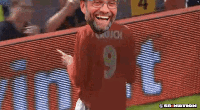 a man wearing a red jersey with the number 9 on it is laughing