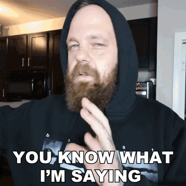 a man with a beard is wearing a black hoodie that says you know what i 'm saying