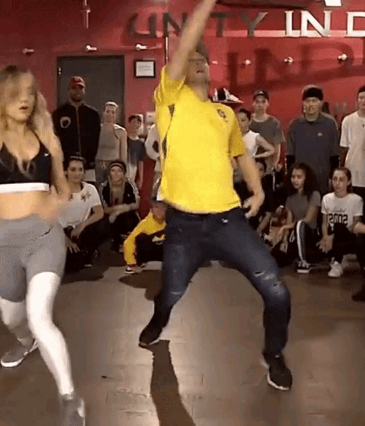 a group of people dancing in front of a sign that says unity inc.