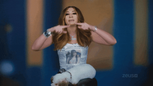 a woman is holding a small white dog and wearing a shirt that says booty the boss