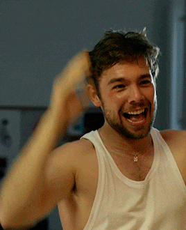 a man with a beard wearing a white tank top