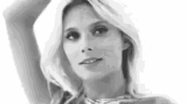 a black and white photo of a woman with blonde hair and a necklace .