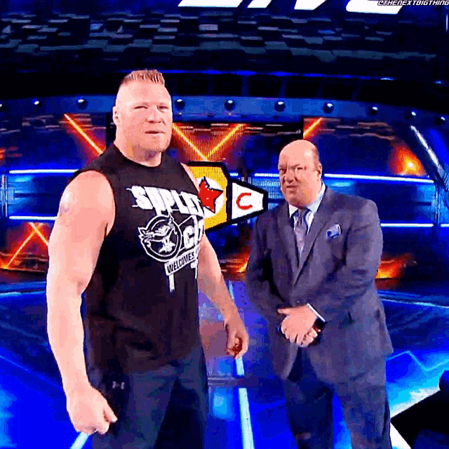 a man wearing a shirt that says ' smackdown welcomes ' stands next to another man in a suit