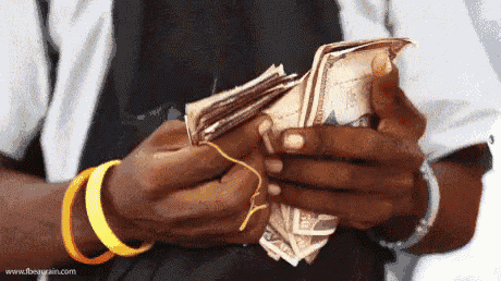 a man is holding a pile of money in his hands