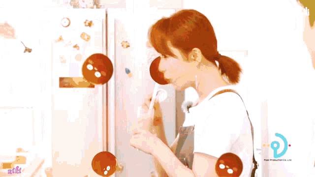 a woman in an apron drinking a milkshake with a straw in front of a fridge that says bli