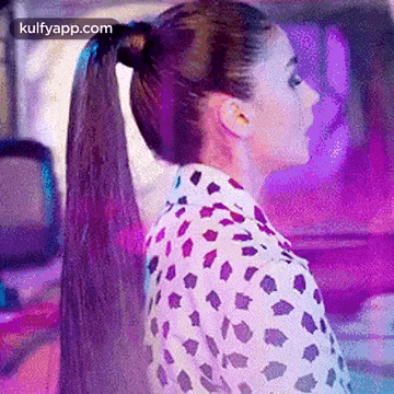 a woman with long hair in a ponytail is standing in front of a car .