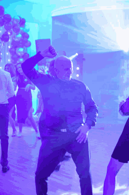 a group of people are dancing in a dark room