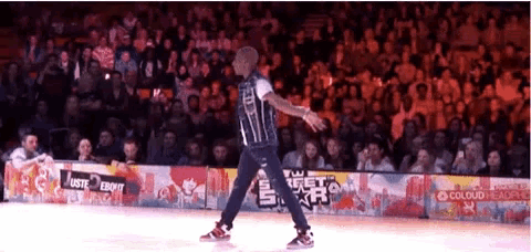 a man dancing in front of a crowd with a sign that says colour