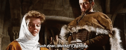 a man and a woman are standing next to each other and the woman is saying hush dear mother is fighting .
