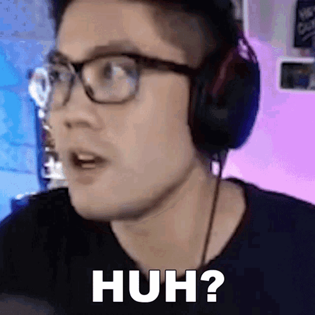a man wearing glasses and headphones is making a funny face and saying huh ?
