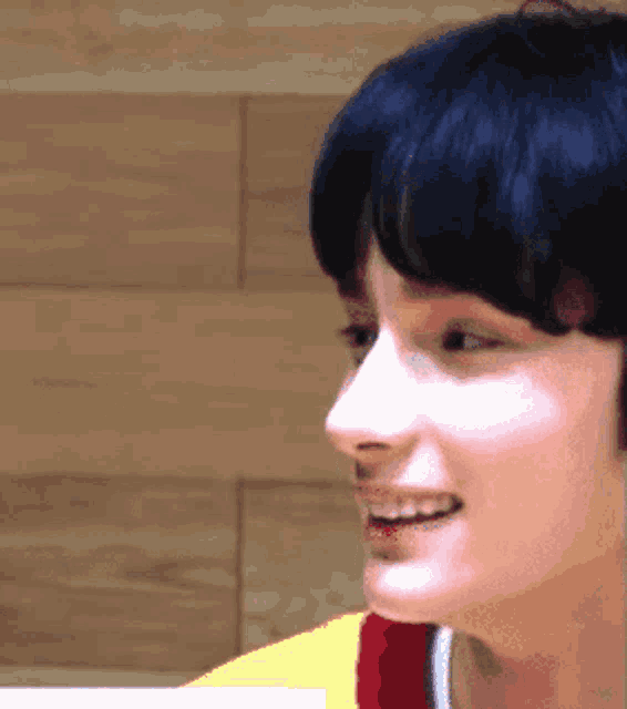 a close up of a person 's face with a yellow and red shirt on
