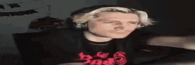 a man with blonde hair is wearing headphones and a black shirt .