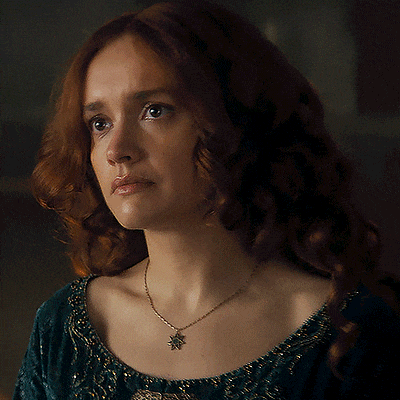 a woman with red hair is wearing a necklace with a leaf pendant