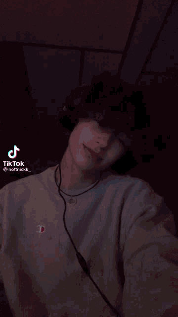 a young man is wearing headphones and a tiktok sticker