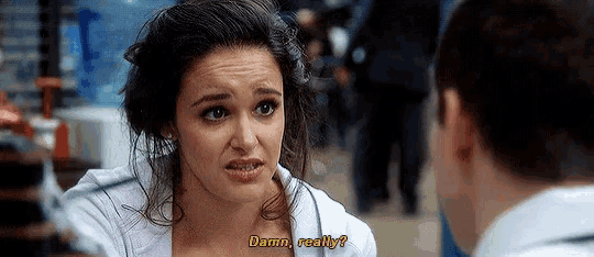 a woman in a white shirt is talking to a man and says damn really