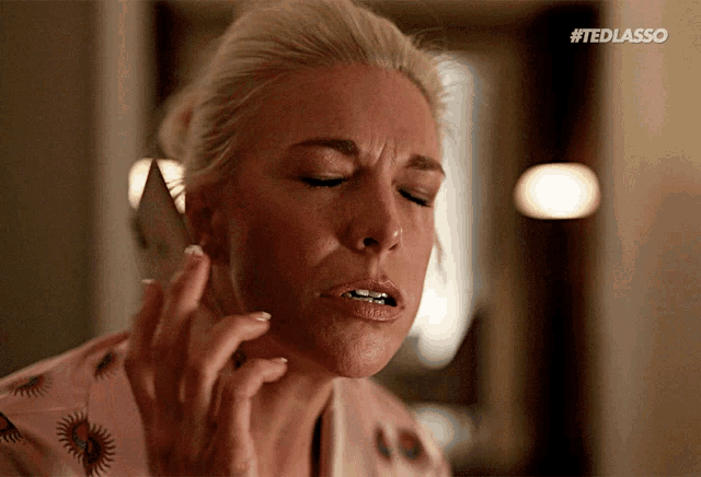 a woman is talking on a cell phone with the hashtag #tedlasso on the bottom right
