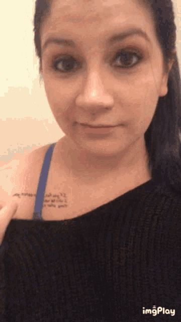 a woman with purple hair has a tattoo on her chest