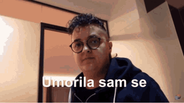 a man wearing glasses and a blue hoodie says umorile sam se in white letters