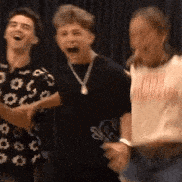 a group of young people are standing next to each other and laughing together .