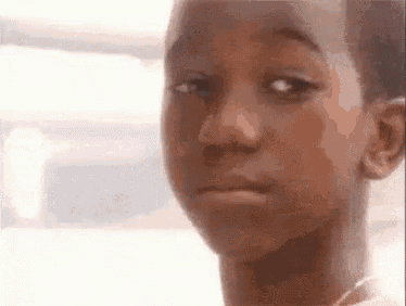 a close up of a young boy 's face making a funny face .