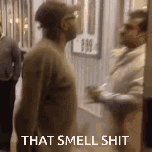 a man standing in a hallway with the words that smell shit written on the bottom