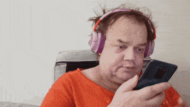 a man wearing headphones is looking at a phone