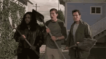 three men are standing next to each other holding shovels in front of a blue house .
