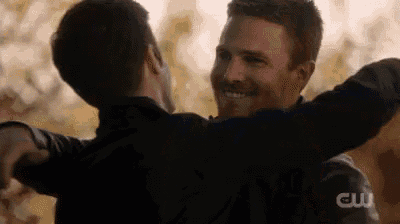 two men are hugging each other and smiling in a close up .