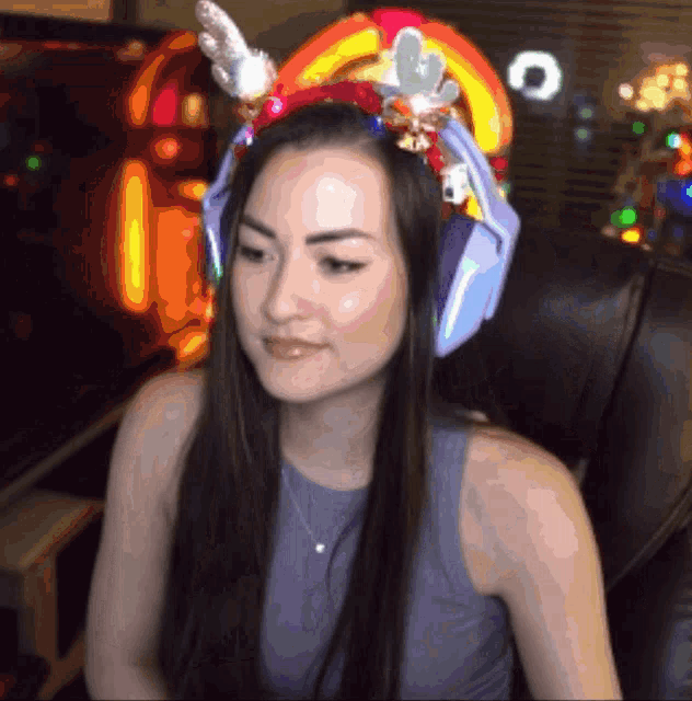 a woman wearing a headband with reindeer antlers and bells