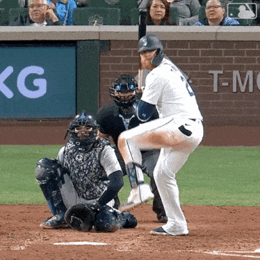 a baseball player getting ready to hit the ball with a t-mobile sign behind him