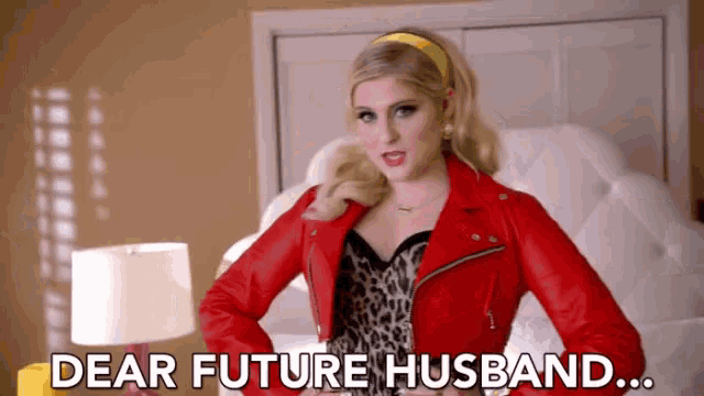 a woman in a red leather jacket is standing in front of a bed and saying `` dear future husband ... ''