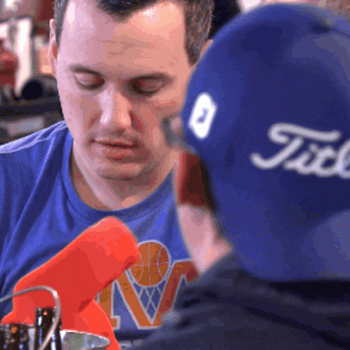 a man wearing a blue shirt and a blue hat that says title