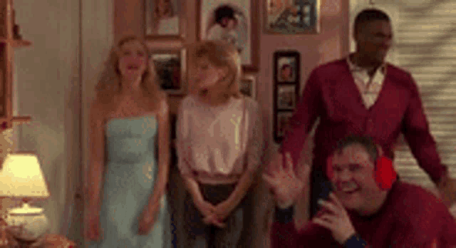 a group of people are standing in a living room .