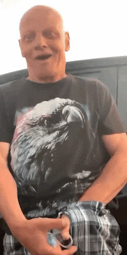 a bald man wearing a black t-shirt with an eagle on it