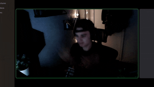 a blurred image of a man in a dark room with a green border around him