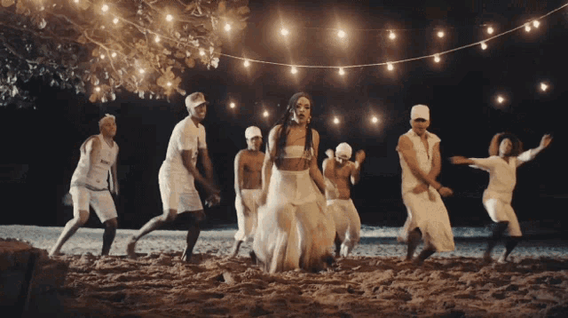 a woman in a white dress is surrounded by men in white shorts